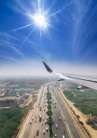 Aerial view of airplane against sky on sunny day