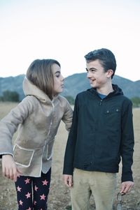Young couple standing against sky