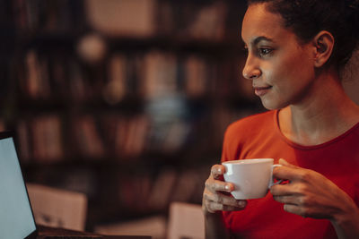Close-up of young woman holding coffee cup