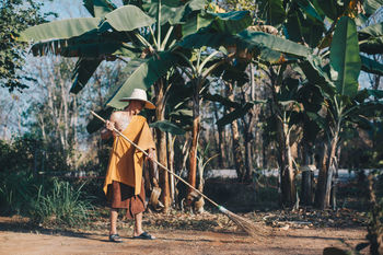MAN WORKING WITH UMBRELLA STANDING IN PARK