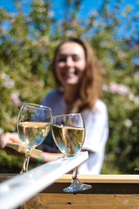 Portrait of a smiling young woman with drink on table