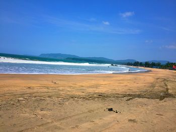 Scenic view of beach against blue sky