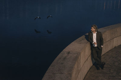 Senior man standing at the lakeside in the evening