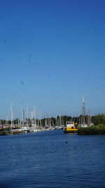 Sailboats in sea against blue sky