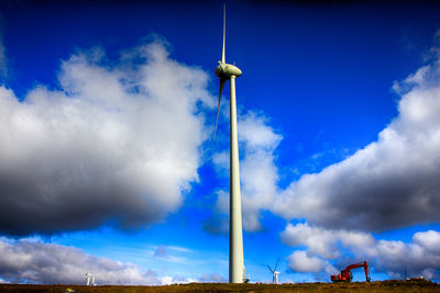 Low angle view of windmill against blue sky