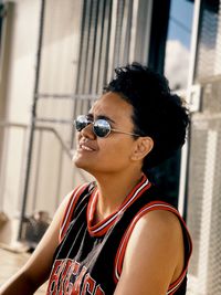 Young woman wearing sunglasses sitting outdoors