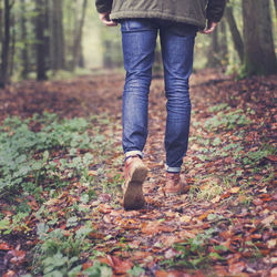 Low section of woman standing in forest