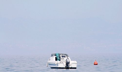 Boat sailing in sea against sky