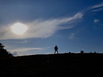 Silhouette person standing on field against sky