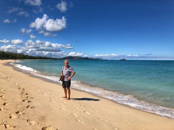 Full length of man standing on beach against sky