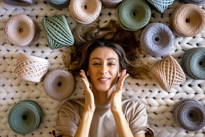 Happy woman amidst multi colored threads