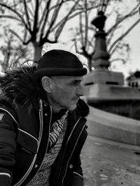 Mature man wearing warm clothing while looking away in city