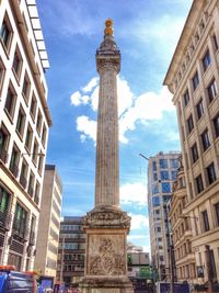 Low angle view of buildings against cloudy sky