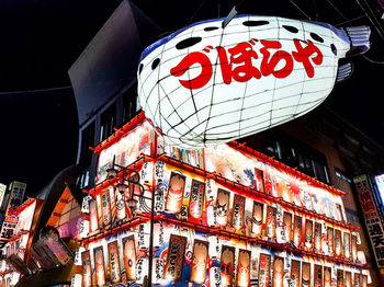 Low angle view of illuminated lanterns hanging in city at night