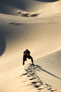 Rear view of woman walking at beach