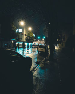 Illuminated city street against sky at night