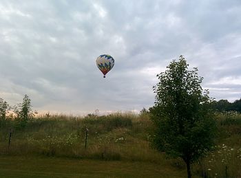 Hot air balloon flying over cloudy sky