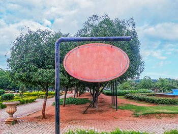 Trees on field against cloudy sky
