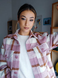 Portrait of a beautiful young woman standing at home