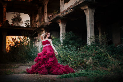 Portrait of woman standing against built structure