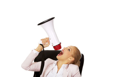 Portrait of young woman holding glass against white background