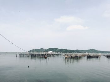 Fishing nets in sea against sky