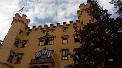 Low angle view of buildings against cloudy sky