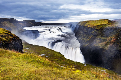 Scenic view of waterfall against sky