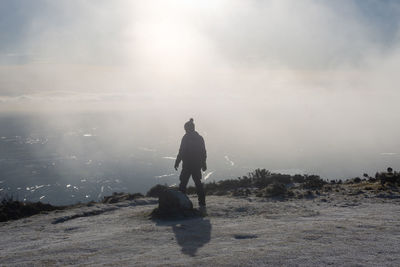 Rear view of man on land against sky