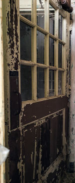 Abandoned building seen through metal window