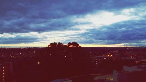 Cityscape against cloudy sky at dusk