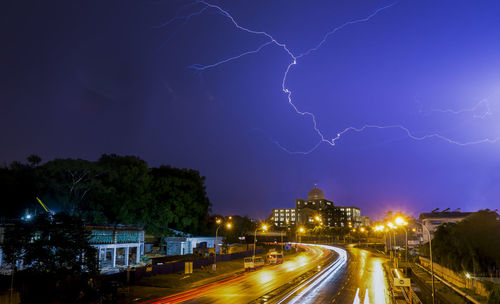 Light trails on street against sky at night