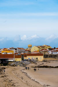 Beach by buildings against sky