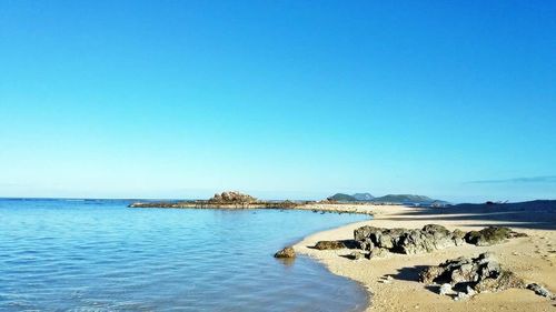 Scenic view of sea against clear blue sky