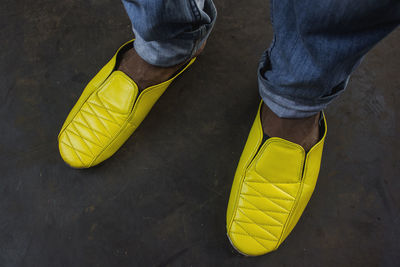 Low section of man wearing yellow shoes