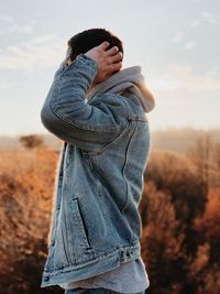 Man in jacket standing against plants