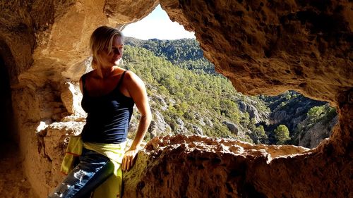 Young woman standing on rock formation in cave