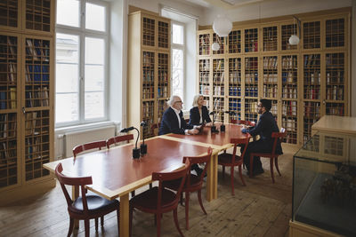 Happy lawyers sitting at table during meeting in board room