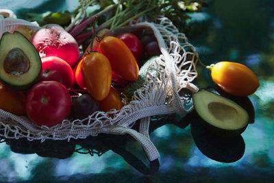 Vegetables yellow tomatoes, beetroot and avocado in eco shopping bag, hard shadows. healthy food. 