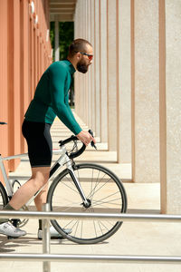 Side view of man riding bicycle on street