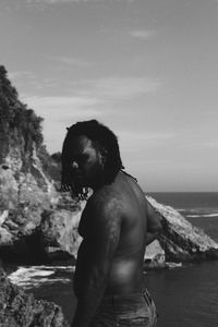 Man looking at sea shore against sky