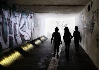 Rear view of people walking in subway tunnel