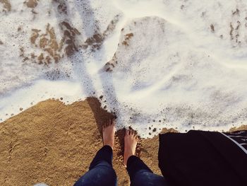 Low section of person standing on beach