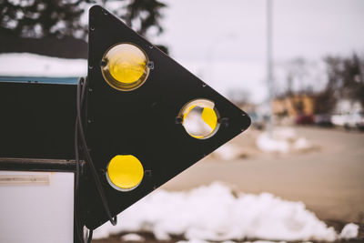 Close-up of arrow symbol on street during winter