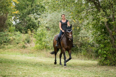 Full length of a young man riding horse