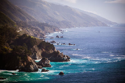 Scenic view of sea and mountains against sky