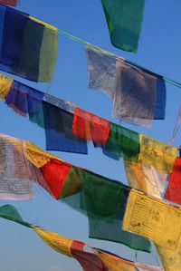 Low angle view of colorful umbrellas hanging against sky