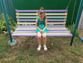 Full length of girl sitting on seat