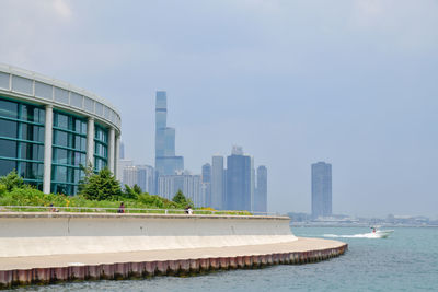 Modern buildings by swimming pool against sky