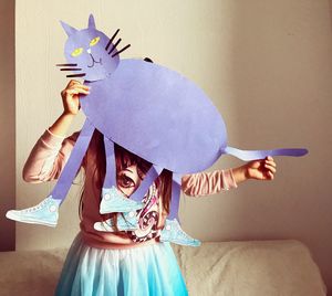 Full length of cute girl flying against paper